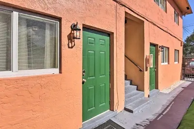 a green door on a orange building with stairs at Fort Lauderdale Apt Near Beaches and Shopping! in Fort Lauderdale