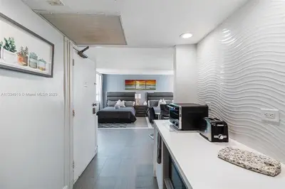 a room with a bed and a kitchen with a counter at 11th Miami Beach - Ocean View -Free Valet Parking in Miami Beach