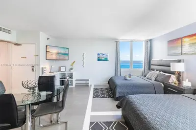a bedroom with a bed and a table and a room at 11th Miami Beach - Ocean View -Free Valet Parking in Miami Beach