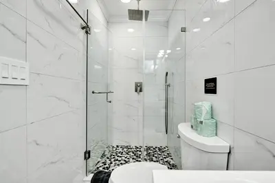 a white bathroom with a shower and a toilet at Deluxe 5BR Villa Heated Pool near Hollywood Beach in Hollywood