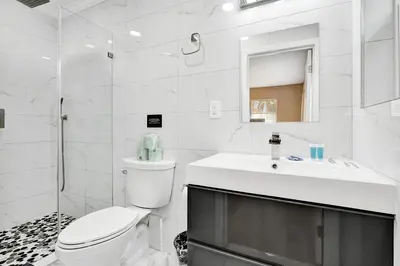 a white bathroom with a toilet and a sink at Deluxe 5BR Villa Heated Pool near Hollywood Beach in Hollywood