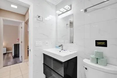 a white bathroom with a sink and a toilet at Deluxe 5BR Villa Heated Pool near Hollywood Beach in Hollywood