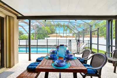 a wooden table with blue dishes on it on a patio at Deluxe 5BR Villa Heated Pool near Hollywood Beach in Hollywood