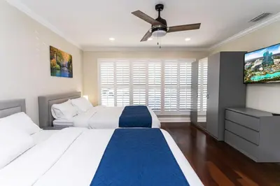 a bedroom with two beds and a flat screen tv at Premium Luxury 5BR Villa near Hollywood Beach in Hollywood