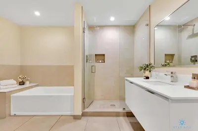 a bathroom with a tub and two sinks and a shower at Front Bay View Terrace Rooftop Pool Near Beach in Hollywood