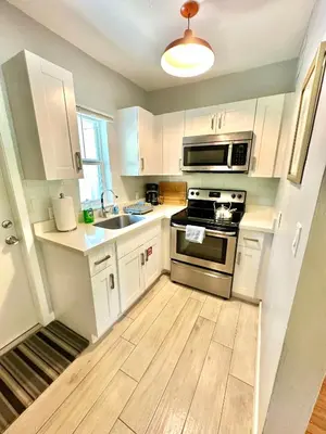 a kitchen with white cabinets and a stove top oven at Las Olas 1BR Pool Free Parking Ideal for 2 in Fort Lauderdale