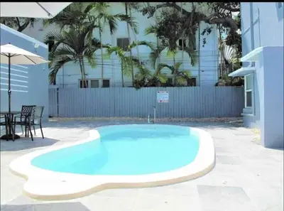 a large blue swimming pool with a table and an umbrella at Unique Las Olas Stay Pool Free Parking in Fort Lauderdale