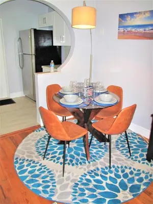 a dining room table and chairs on a rug at Unique Las Olas Stay Pool Free Parking in Fort Lauderdale