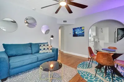 a living room with a blue couch and a table at Unique Las Olas Stay Pool Free Parking in Fort Lauderdale