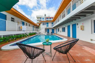 a pool in the courtyard of a building with two chairs at Beachfront Studio with Pool access -M24 in Hollywood