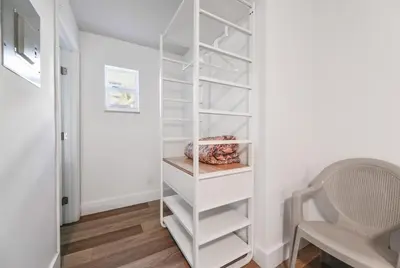 a walk in closet with white shelves and a chair at Beachfront Studio with Pool access -M24 in Hollywood