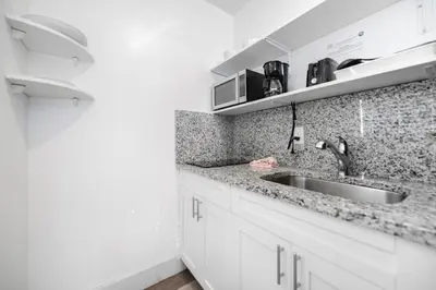 a kitchen with white cabinets and a sink at Family Friendly Beach Escape with pool and parking - M41 in Hollywood