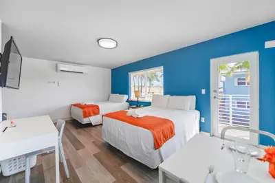 a room with two beds and a table and a desk at Family Friendly Beach Escape with pool and parking - M41 in Hollywood