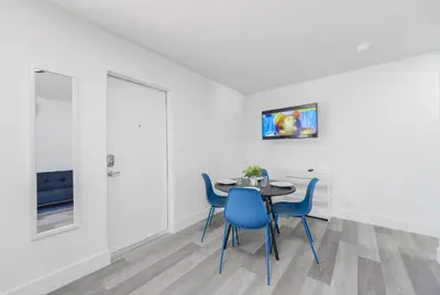 a dining room with a table and blue chairs at Peaceful Studio by the Beach with Parking - M25 in Hollywood