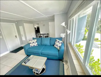 a living room with a blue couch and a table at Walk to Las Olas Pool Perfect Couples Stay in Fort Lauderdale