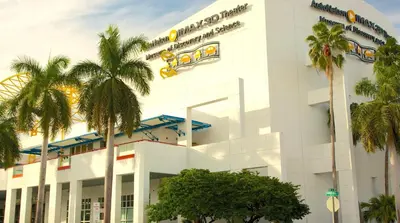 a white building with palm trees in front of it at Walk to Las Olas Pool Perfect Couples Stay in Fort Lauderdale