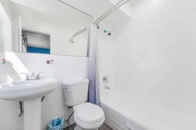 a white bathroom with a toilet and a sink at Spacious Oceanfront Studio with pool access - M27 in Hollywood