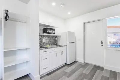 a white kitchen with white cabinets and a window at Spacious Oceanfront Studio with pool access - M27 in Hollywood