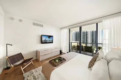 a white bedroom with a large bed and a large window at Private Residence at South Beach - 811 in Miami Beach