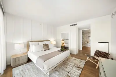 a white bedroom with a bed and a desk at Private Residence at South Beach - 811 in Miami Beach
