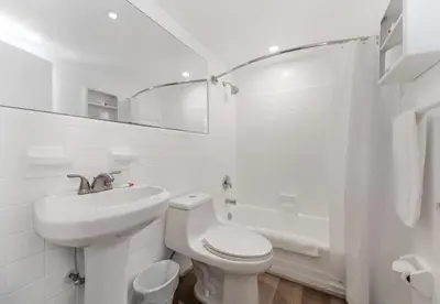 a white bathroom with a toilet and a sink at Wonderful Studio with pool and parking at the beach! M31 in Hollywood