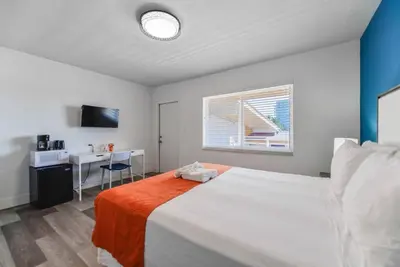 a bedroom with a large white bed and a desk at Comfortable Beachfront Studio with pool! -M32 in Hollywood