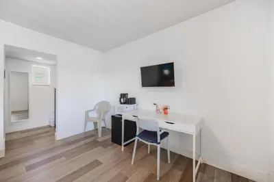 a room with a white desk and a table with chairs at Comfortable Beachfront Studio with pool! -M32 in Hollywood