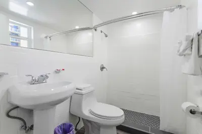 a white bathroom with a toilet and a sink at Spacious unit with pool and parking - M33 in Hollywood