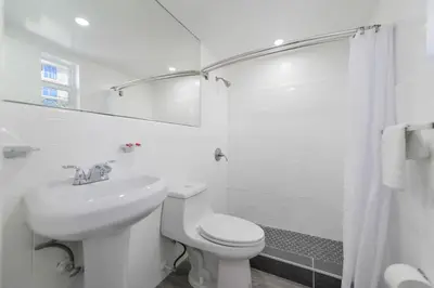 a white bathroom with a toilet and a sink at Serene Studio by the Beach with pool - M34 in Hollywood