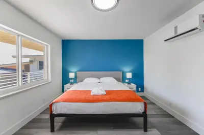 a bedroom with a bed with a blue wall at Serene Studio by the Beach with pool - M34 in Hollywood