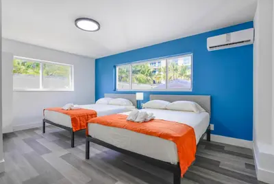 two beds in a room with blue walls and windows at Outstanding oceanfront unit With Parking&Pool - M36 in Hollywood