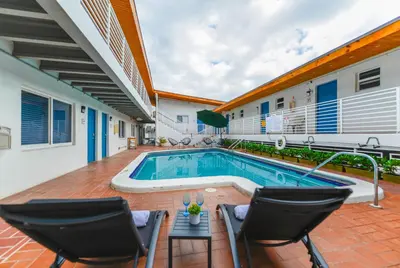 a swimming pool in a house with two chairs and a table at Outstanding oceanfront unit With Parking&Pool - M36 in Hollywood