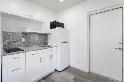 a white kitchen with white cabinets and a refrigerator at Magical Beach Escape with Pool -M37 in Hollywood