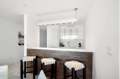 a kitchen with three bar stools and a sink at Ocean View Residence at South Beach -1114 in Miami Beach