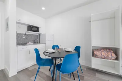 a dining room with a black table and blue chairs at Ocean view Balcony with Pool & Parking -M42 in Hollywood