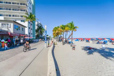 a beach with people and palm trees and people riding a bike at Fantastic Studio at the Beach with Parking&Pool - M43 in Hollywood