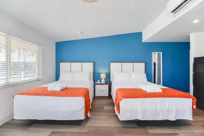 two beds in a bedroom with a blue wall at Spacious studio with Balcony and Parking at the Beach -M46 in Hollywood