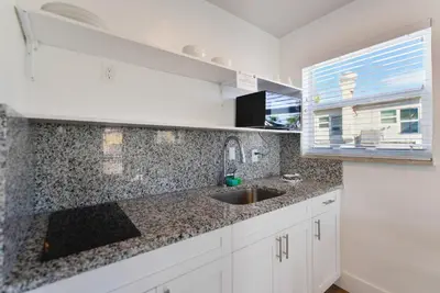 a white kitchen with a sink and a window at Spacious studio with Balcony and Parking at the Beach -M46 in Hollywood