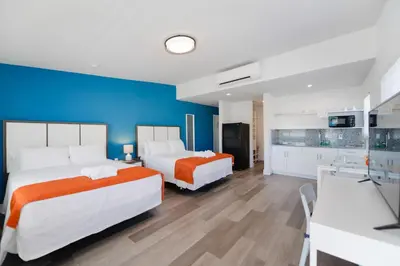 two beds in a room with a blue wall at Spacious studio with Balcony and Parking at the Beach -M46 in Hollywood