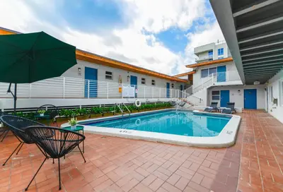 a swimming pool with an umbrella next to a building at Studio with Balcony and Parking - M47 in Hollywood