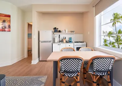 a kitchen with a table and chairs and a refrigerator at Pantera Rosa in Miami Beach