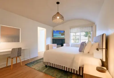 a bedroom with a large white bed and a desk at Pantera Rosa in Miami Beach