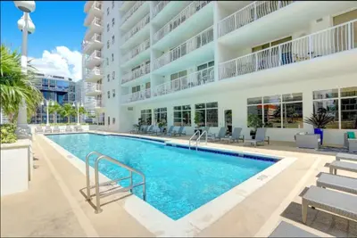 a swimming pool in front of a building at Iconic Sunset Views with Pool, Hot tub, GYM, and Parking in Miami