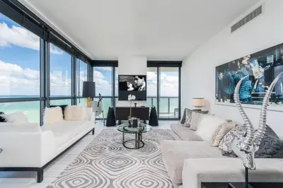 a living room with white furniture and large windows at Stunning 3B Oceanfront at South Beach - 1229 in Miami Beach