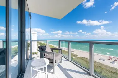 a balcony with a chair and a view of the beach at Stunning 3B Oceanfront at South Beach - 1229 in Miami Beach