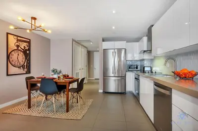 a kitchen with a wooden table and a dining room at Modern Miami Gem - City View Condo - Free Parking in Miami