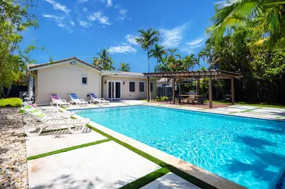 a swimming pool with chairs and a house at Deluxe 5BR & 3BA Villa in Hollywood Lakes near Beach in Hollywood