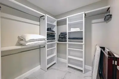 a walk in closet with white shelving at Deluxe 5BR & 3BA Villa in Hollywood Lakes near Beach in Hollywood