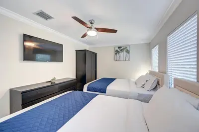 two beds in a bedroom with a ceiling fan at Deluxe 5BR & 3BA Villa in Hollywood Lakes near Beach in Hollywood
