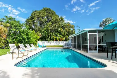 a swimming pool with chairs and a house at Luxury 5BR Villa Heated Pool near Beach & Casino in Dania Beach
